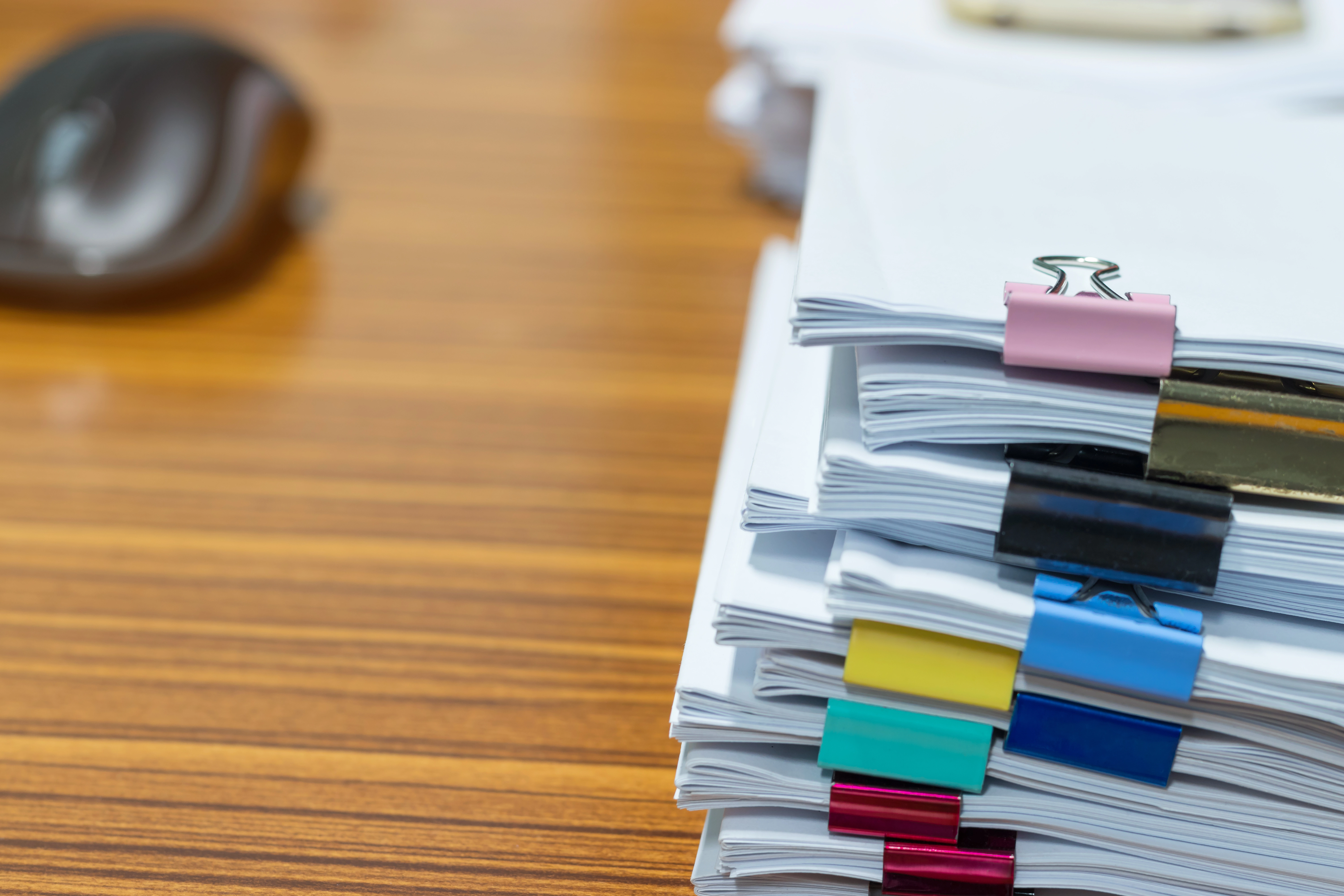 A stack of documents with colourful clips.
